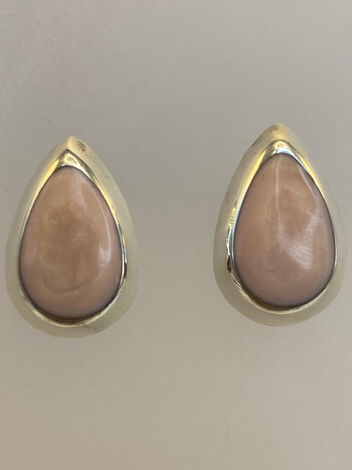 Aretes minimalistas en la oreja, mostrando discreto tamaño de 1.3 cm