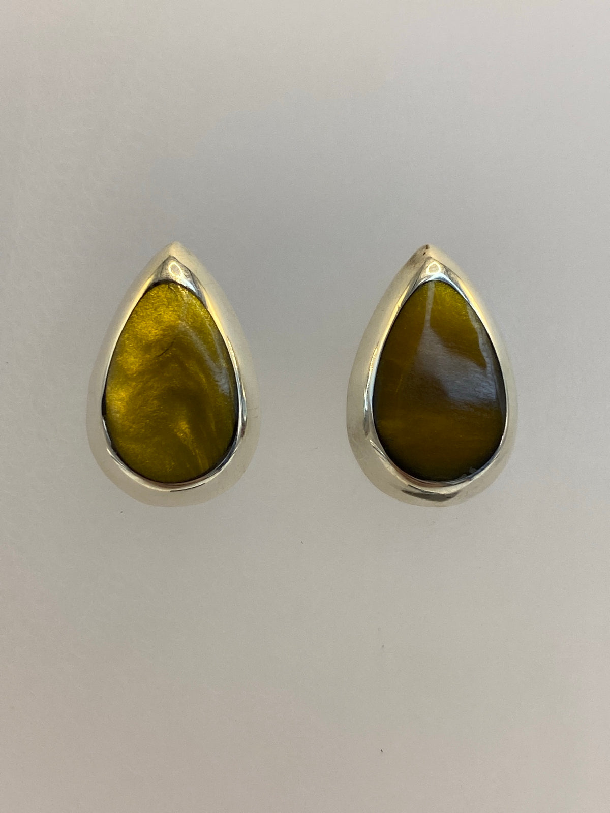 Vista frontal de aretes de plata compactos con piedra multicolor brillante