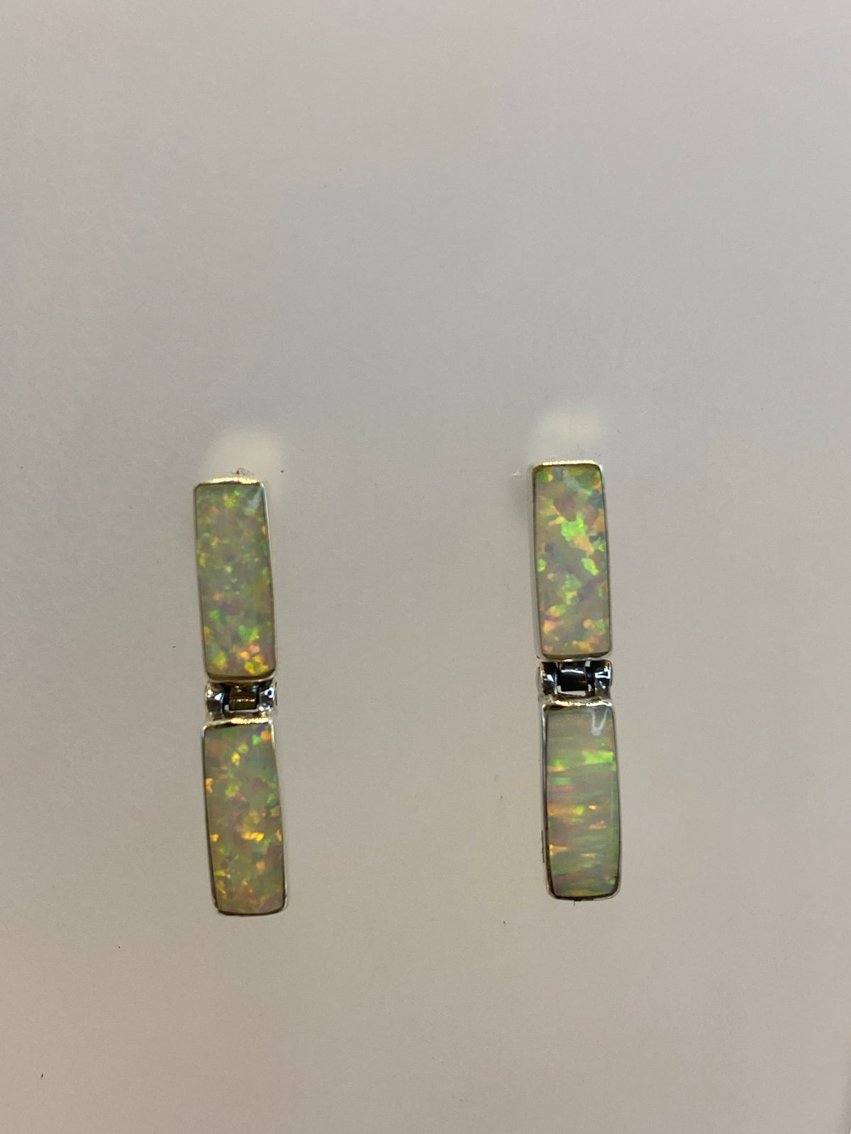 Aretes de plata pura engastados a mano, vista frontal sobre fondo blanco