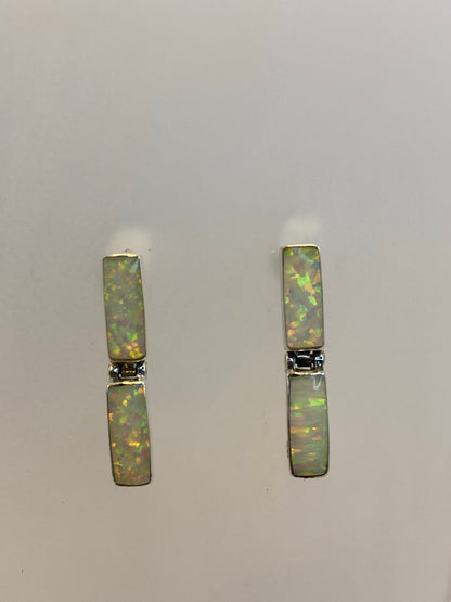 Aretes de plata pura engastados a mano, vista frontal sobre fondo blanco
