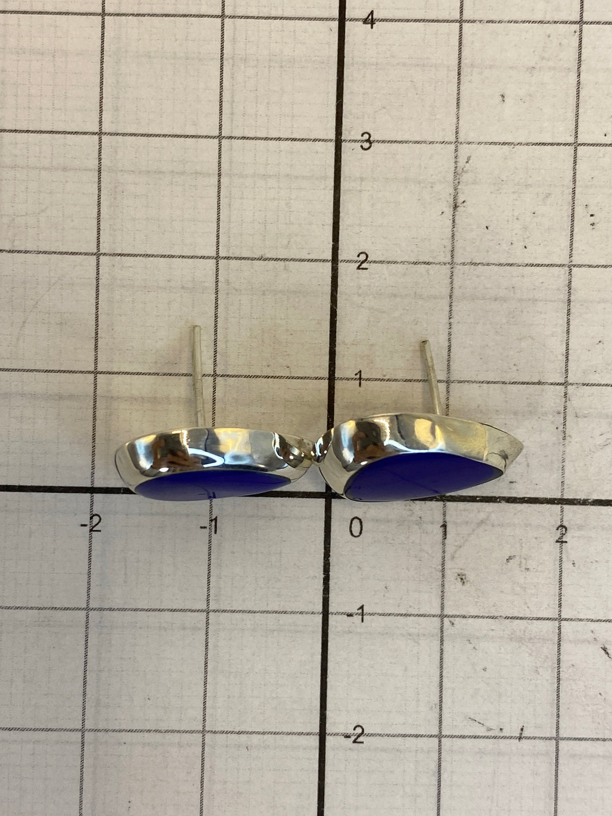 Par de aretes sobre fondo blanco mostrando el Quinto 925
