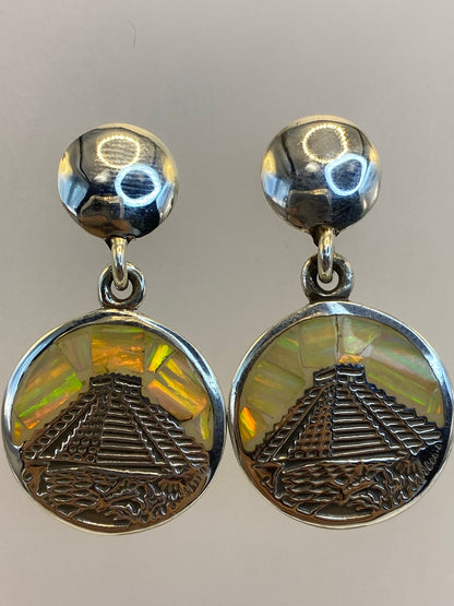 Aretes puestos en una mujer, brillando con los tonos multicolores del ópalo