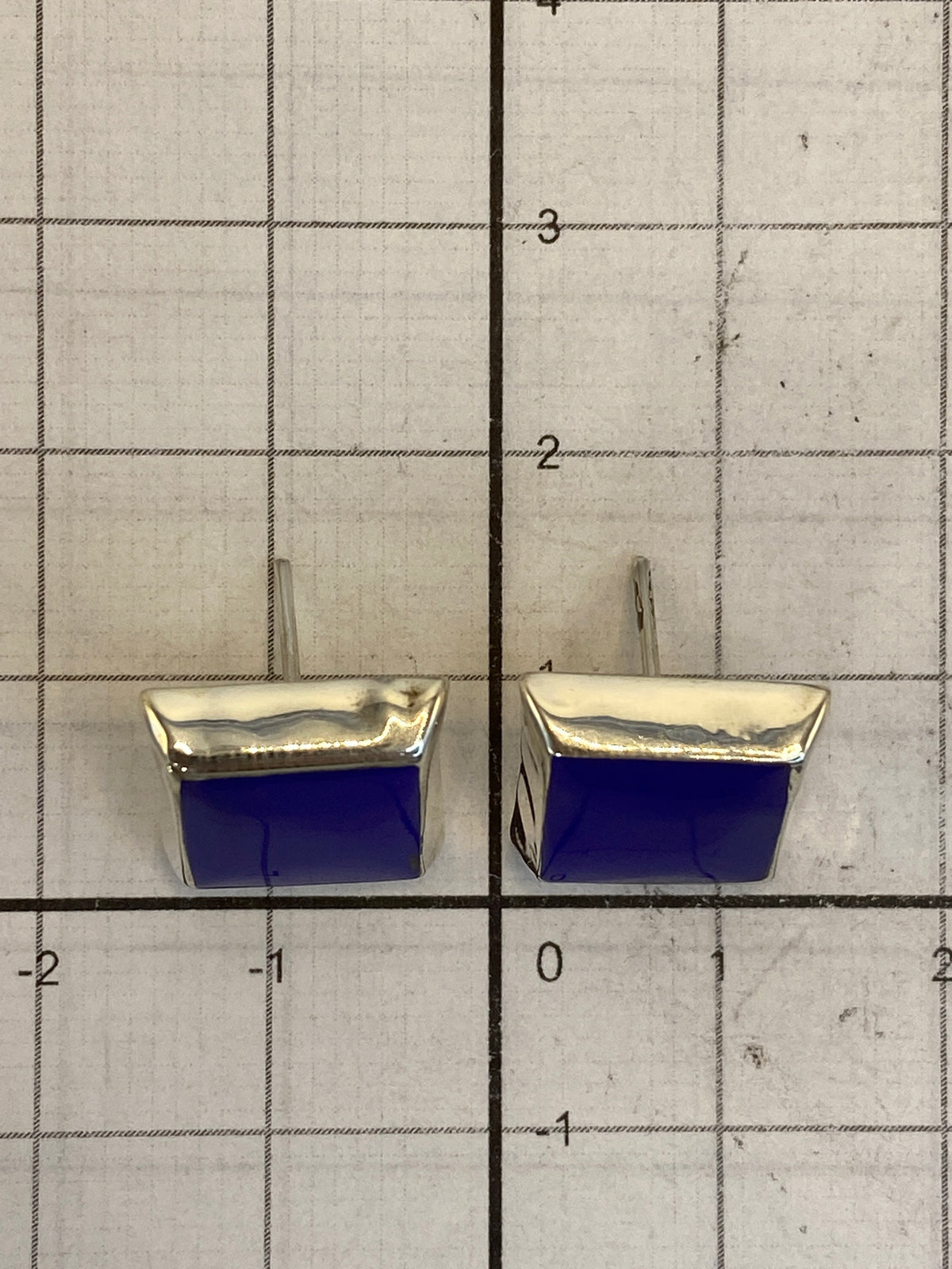 Aretes sobre regla milimetrada para escala de tamaño (1.4 cm), fotografía de producto