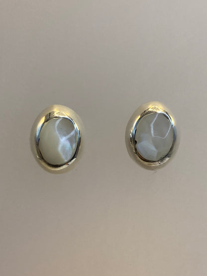 Aretes de plata 925 con piedra engastada a mano, ligeramente curvados, mostrando el brillo del metal