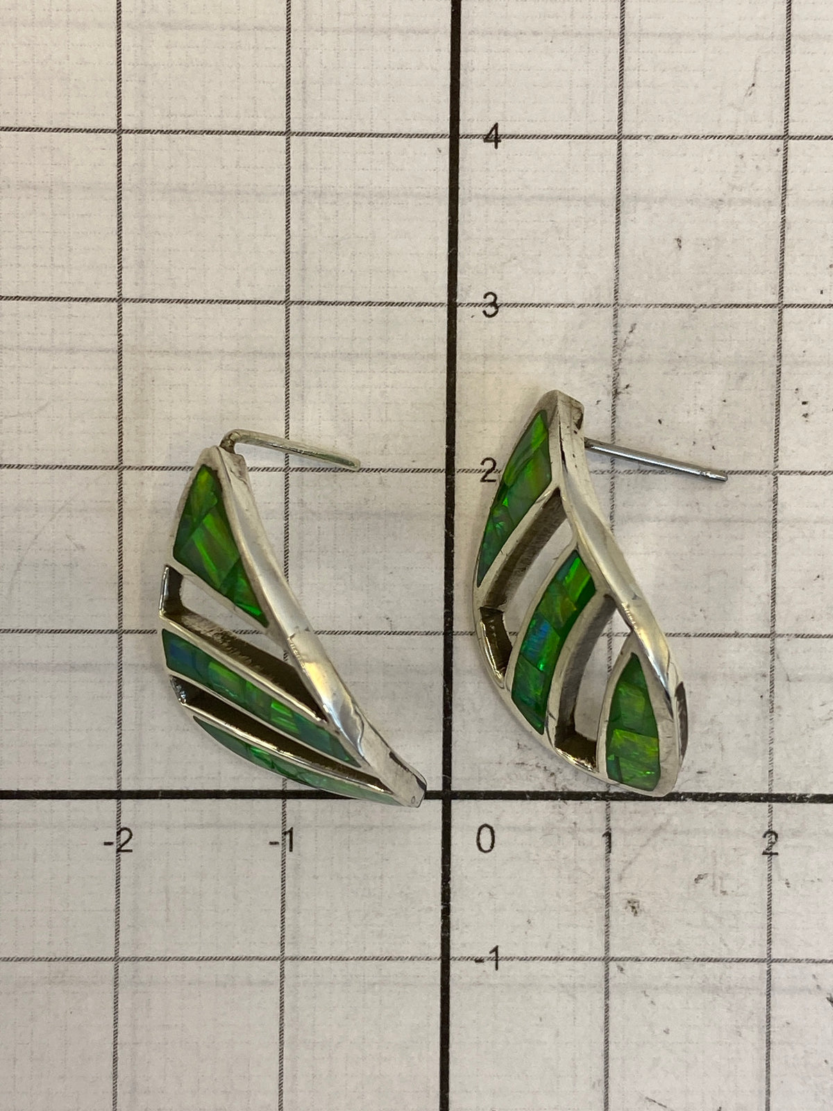 Aretes en la mano mostrando el tamaño real de 1.4 cm