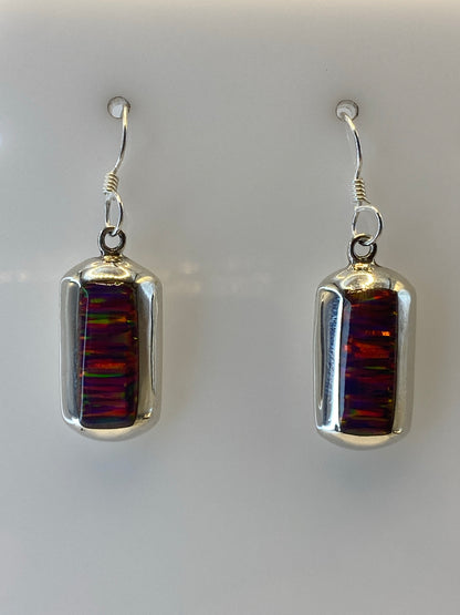 Arete individual mostrando el ópalo de fuego con vetas de rojo, naranja y amarillo en engaste de plata