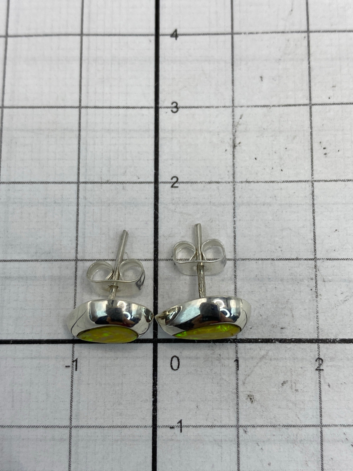 Aretes de ópalo de fuego puestos, reflejando luz cálida