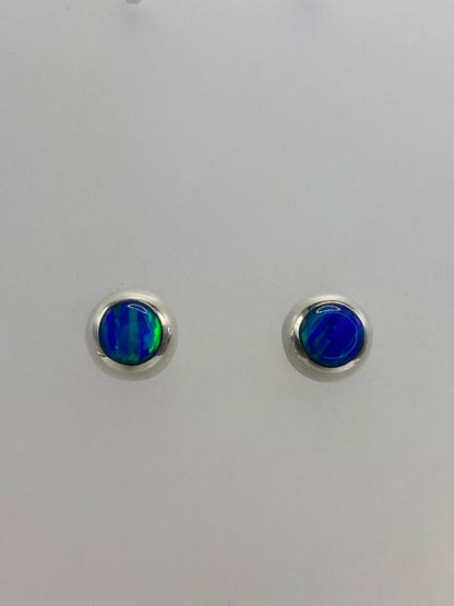 Par de aretes de plata con ópalo de fuego azul verdoso en fondo gris