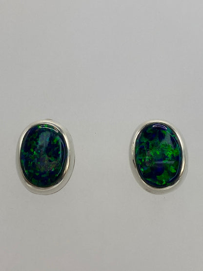 Detalle de la incrustación de ópalo de fuego en los aretes, tono verde oscuro