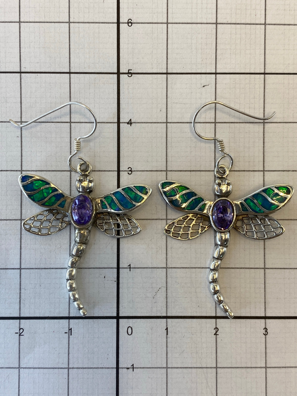 Pair of silver dragonfly earrings with Fire Opal on white background, showing Quinto hallmark