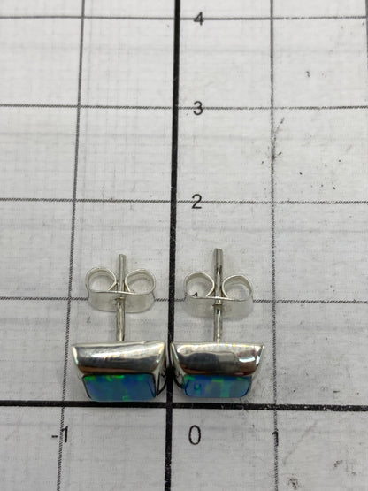 Aretes puestos en comparación de escala con centímetros, largo 1.3 cm