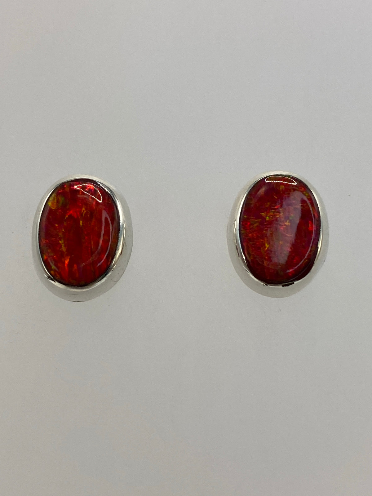 Aretes de ópalo de fuego en plata 925 mostrando el Quinto