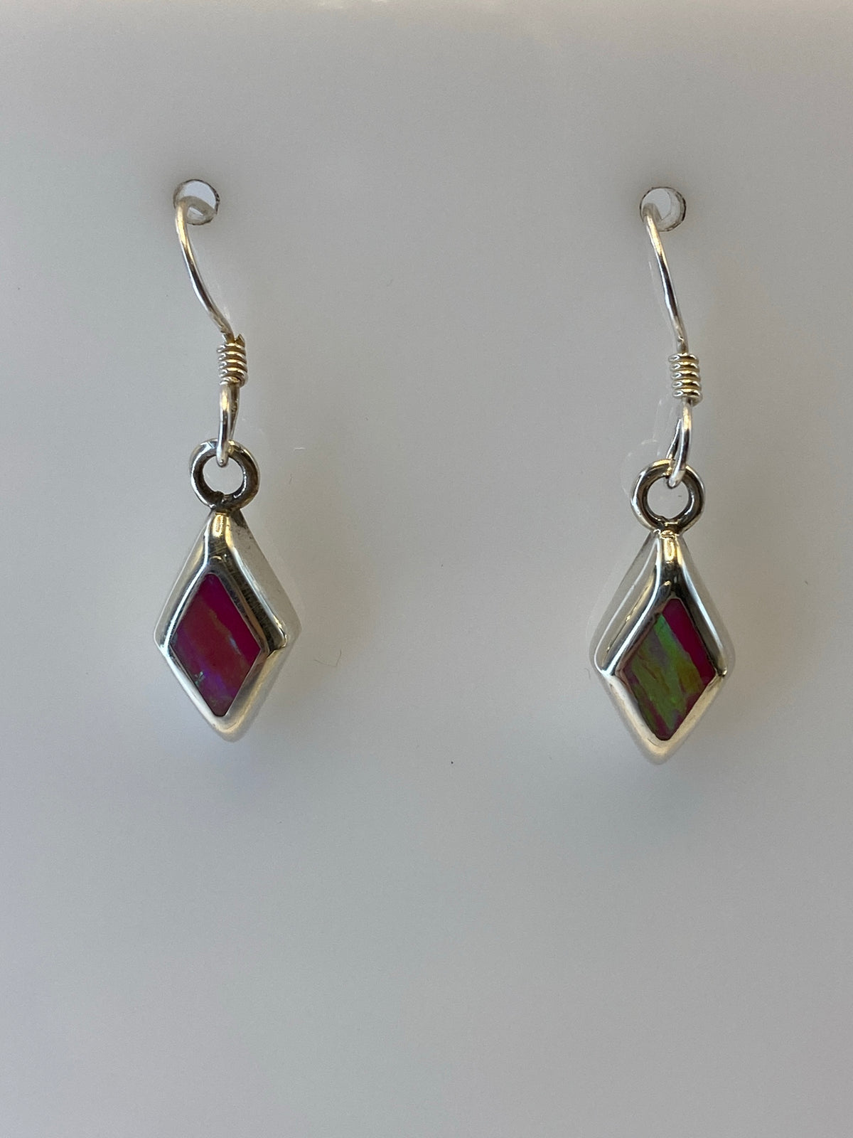 Arete de plata 925 con Ópalo de Fuego mostrando el tono verde olivo a la luz