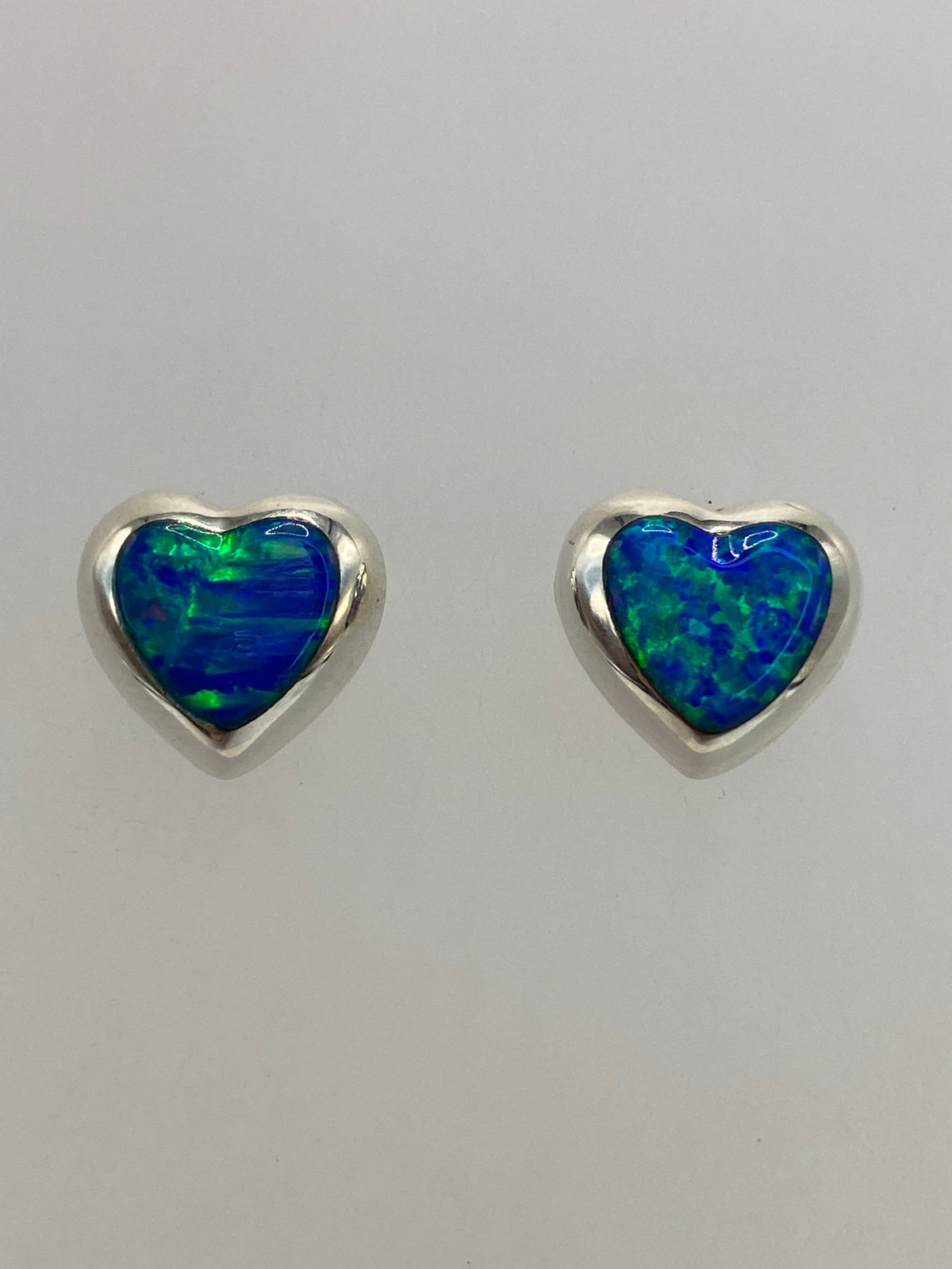 Detalle del ópalo de fuego azul en el arete, mostrando los destellos internos