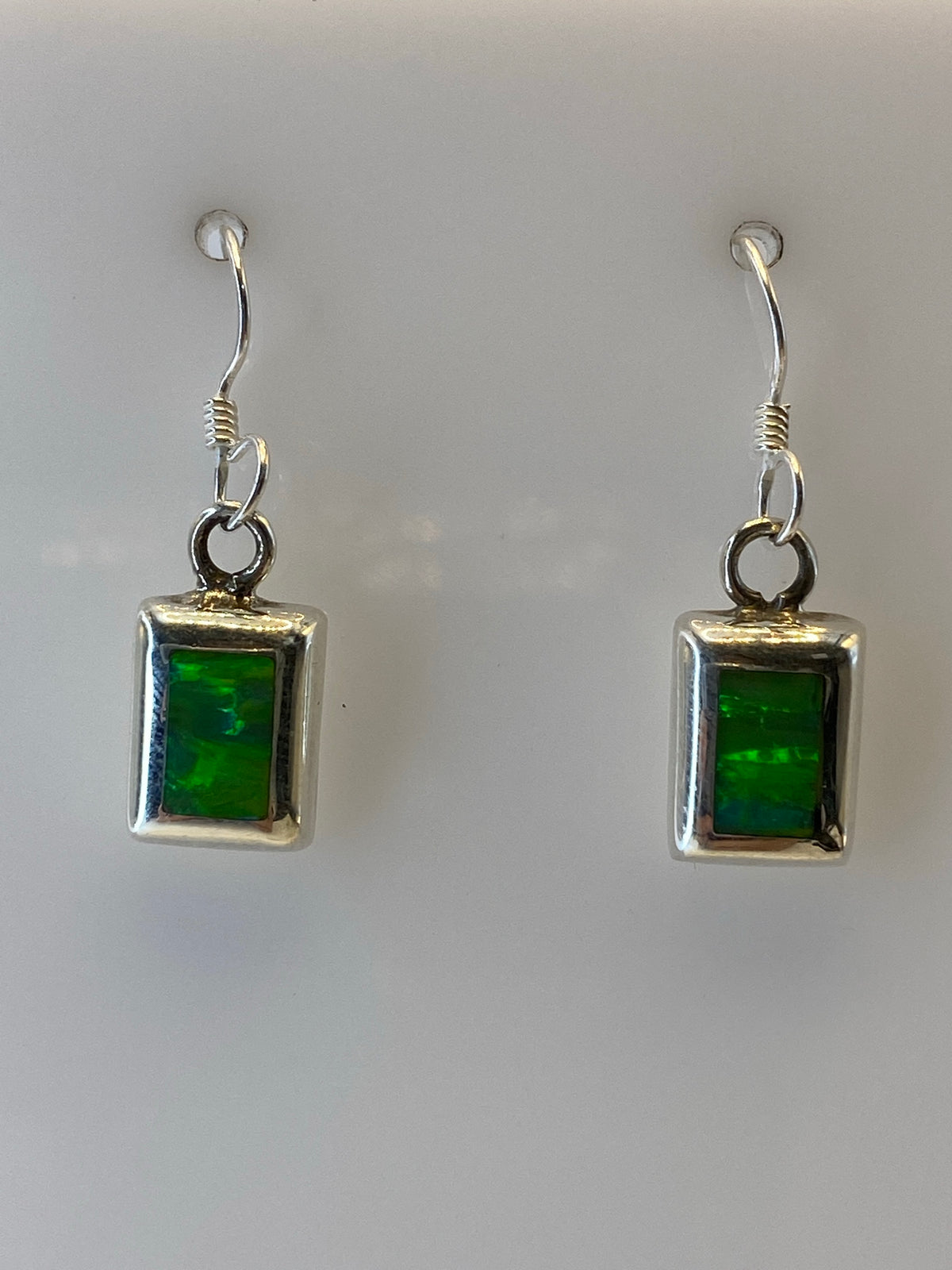 Par de aretes de plata 925 con ópalo de fuego verde olivo engastado, colgando de ganchos de plata