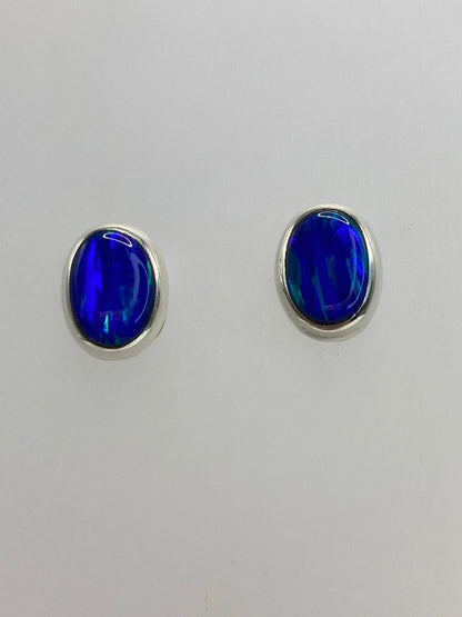 Aretes pequeños de 1.3 cm con piedra azul engastada, lado a lado