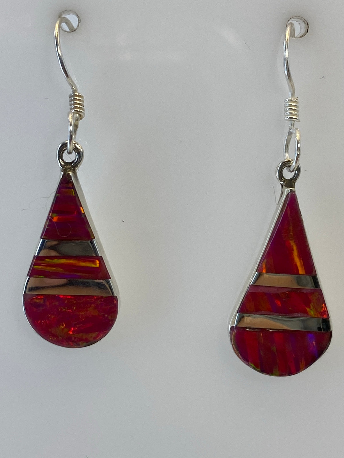 Aretes colgando, mostrando el largo de 3.4 cm y el juego de luces del Ópalo