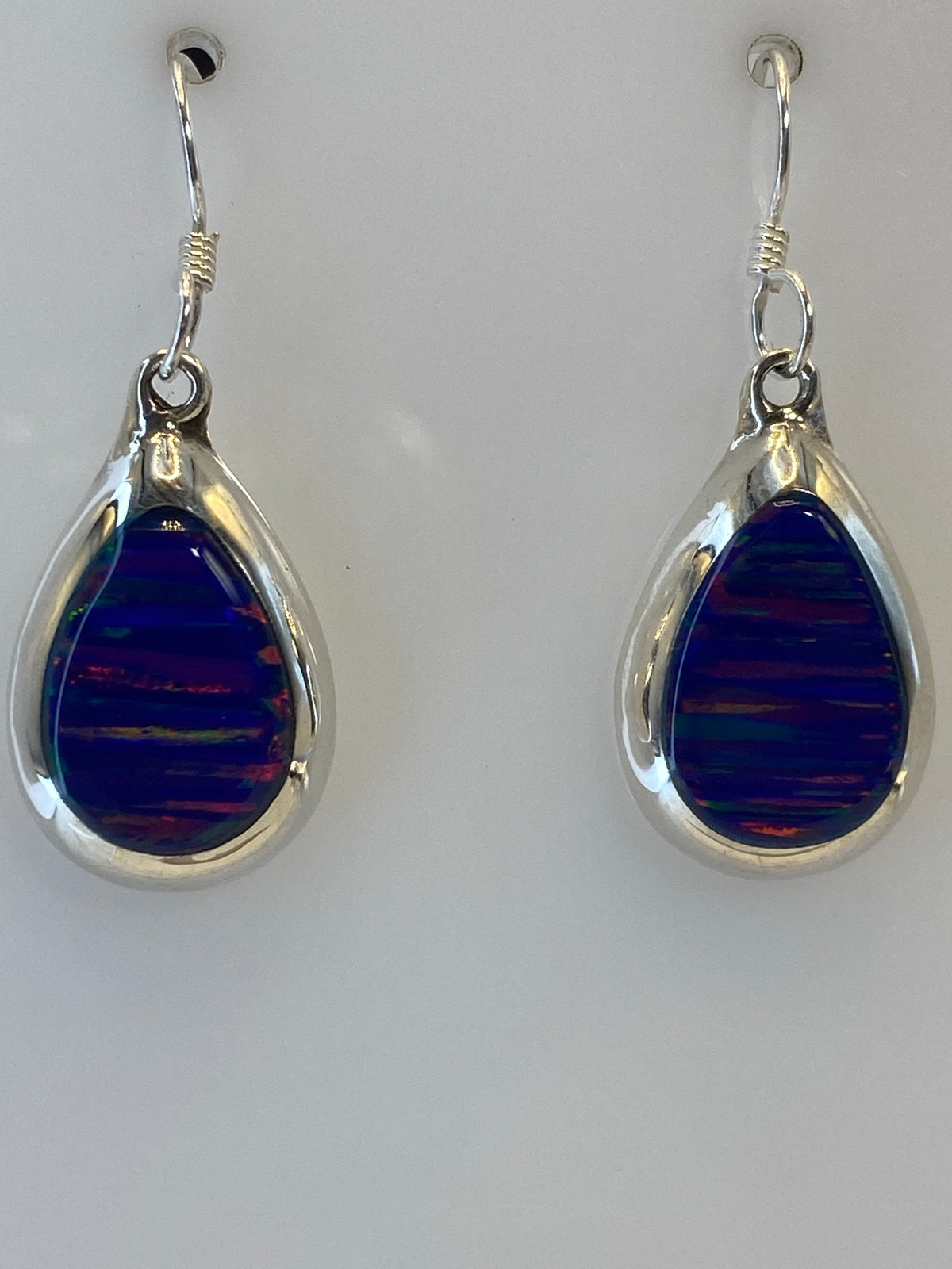 Aretes sobre regla de medidas, mostrando largo de 3.3 cm