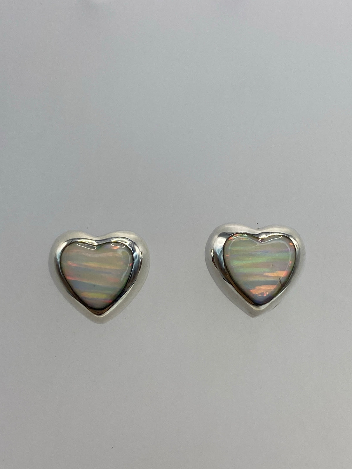 Par de aretes de plata con ópalo de fuego blanco engastado en forma corazón