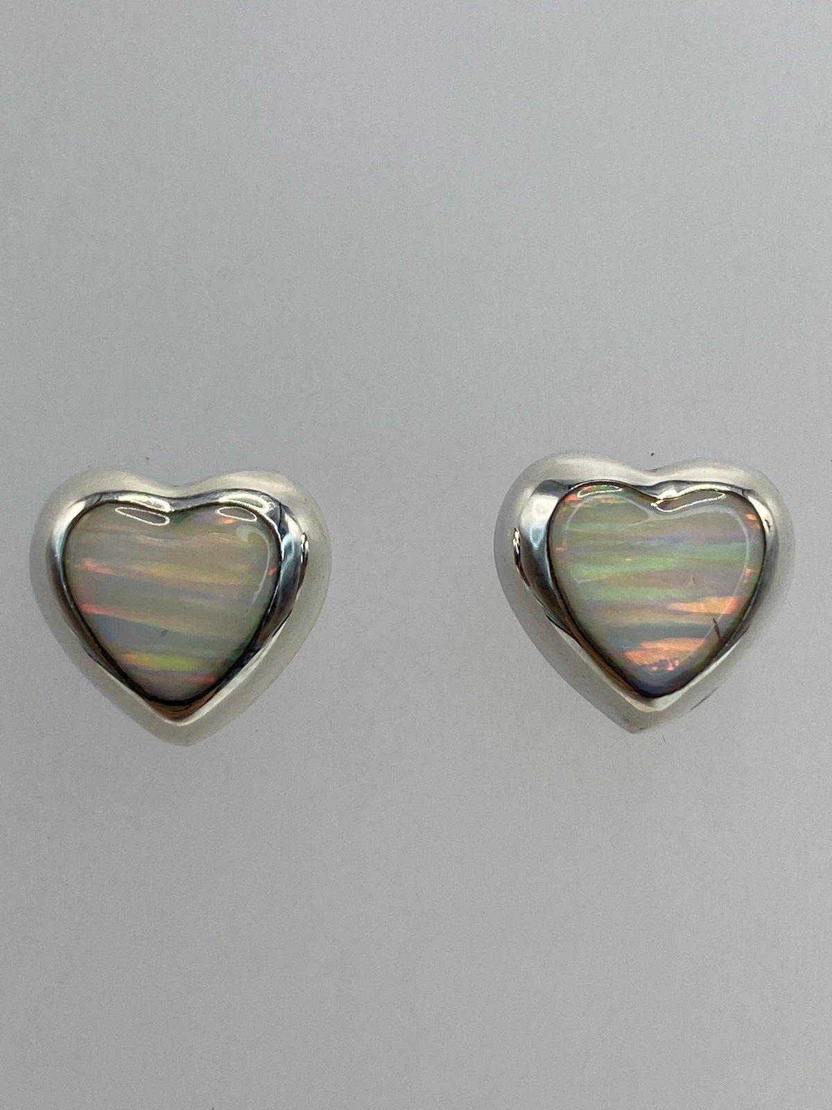 Aretes sobre regla de centímetros mostrando su tamaño delicado de 1.3 cm