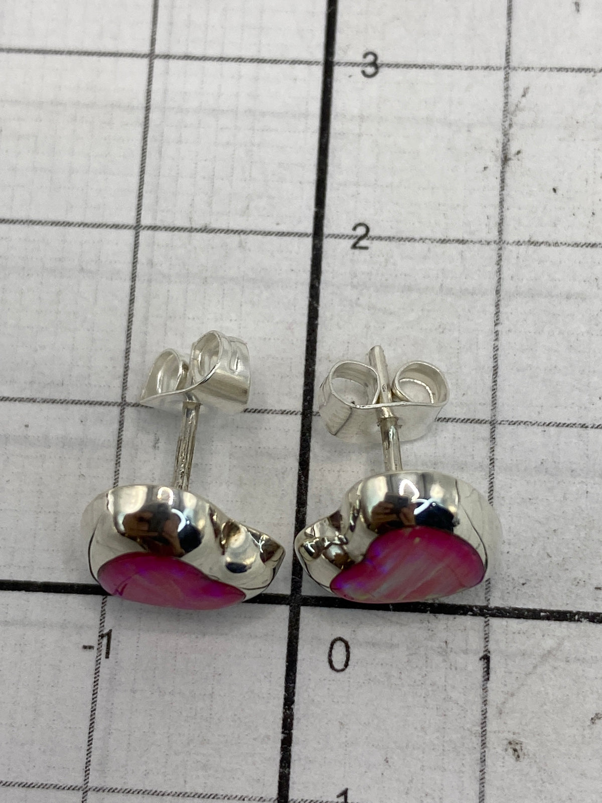 Comparativa de tamaño: aretes con ópalo rosa junto a escala de centímetros