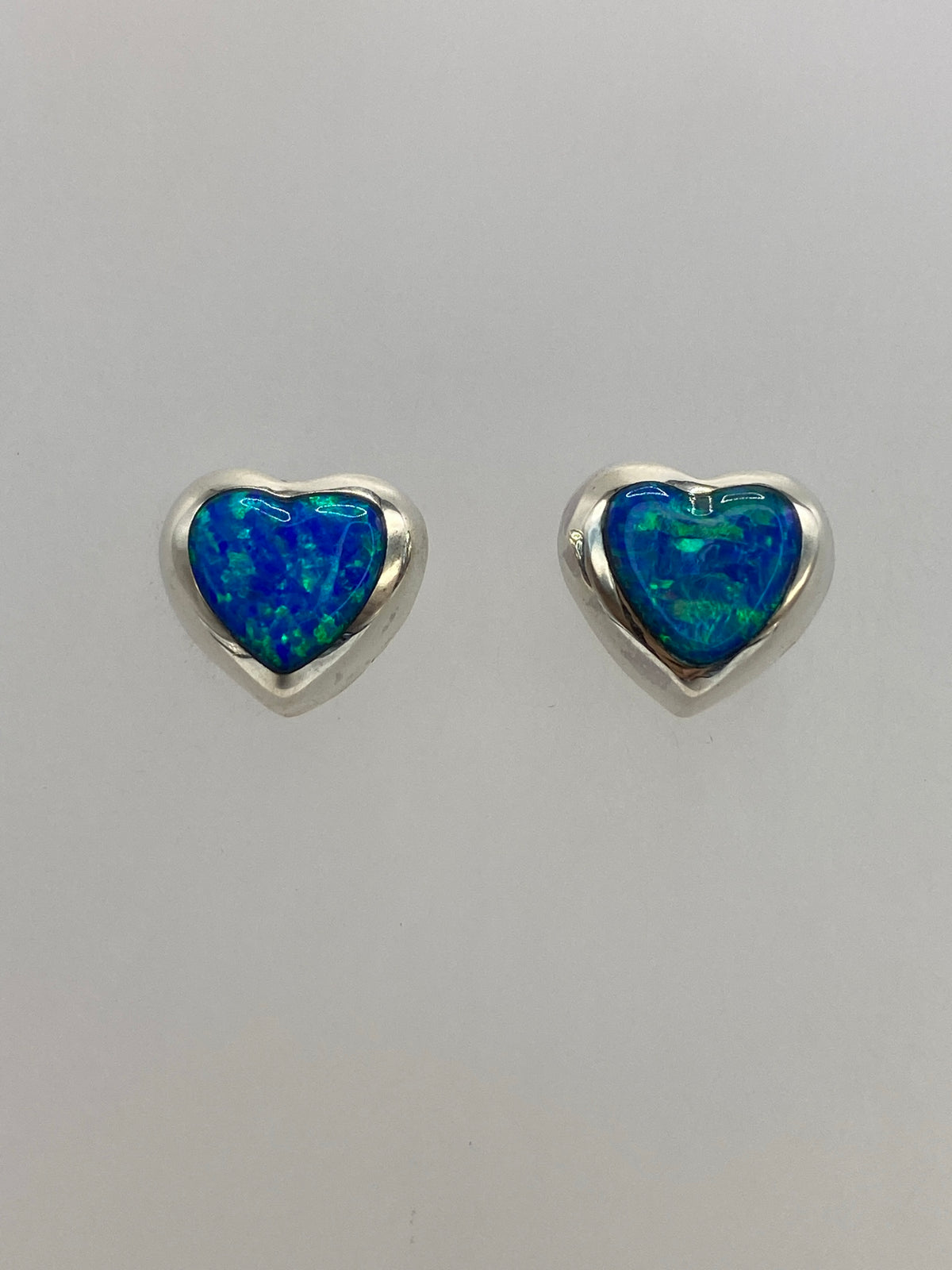 Detalle del ópalo de fuego azul con destellos verdes en arete de plata 925