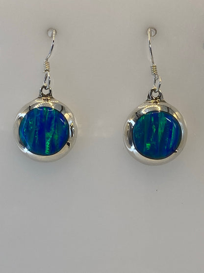 Par de aretes de plata 925 con ópalo de fuego multicolor engastado, colgando sobre fondo blanco