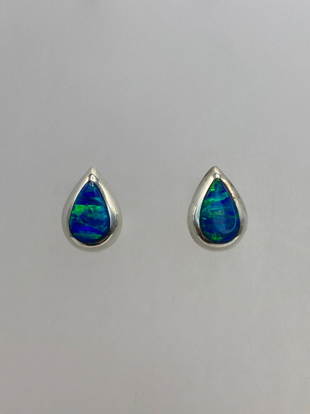Par de aretes de plata 925 con Ópalo de Fuego azul engastado, vistos de frente