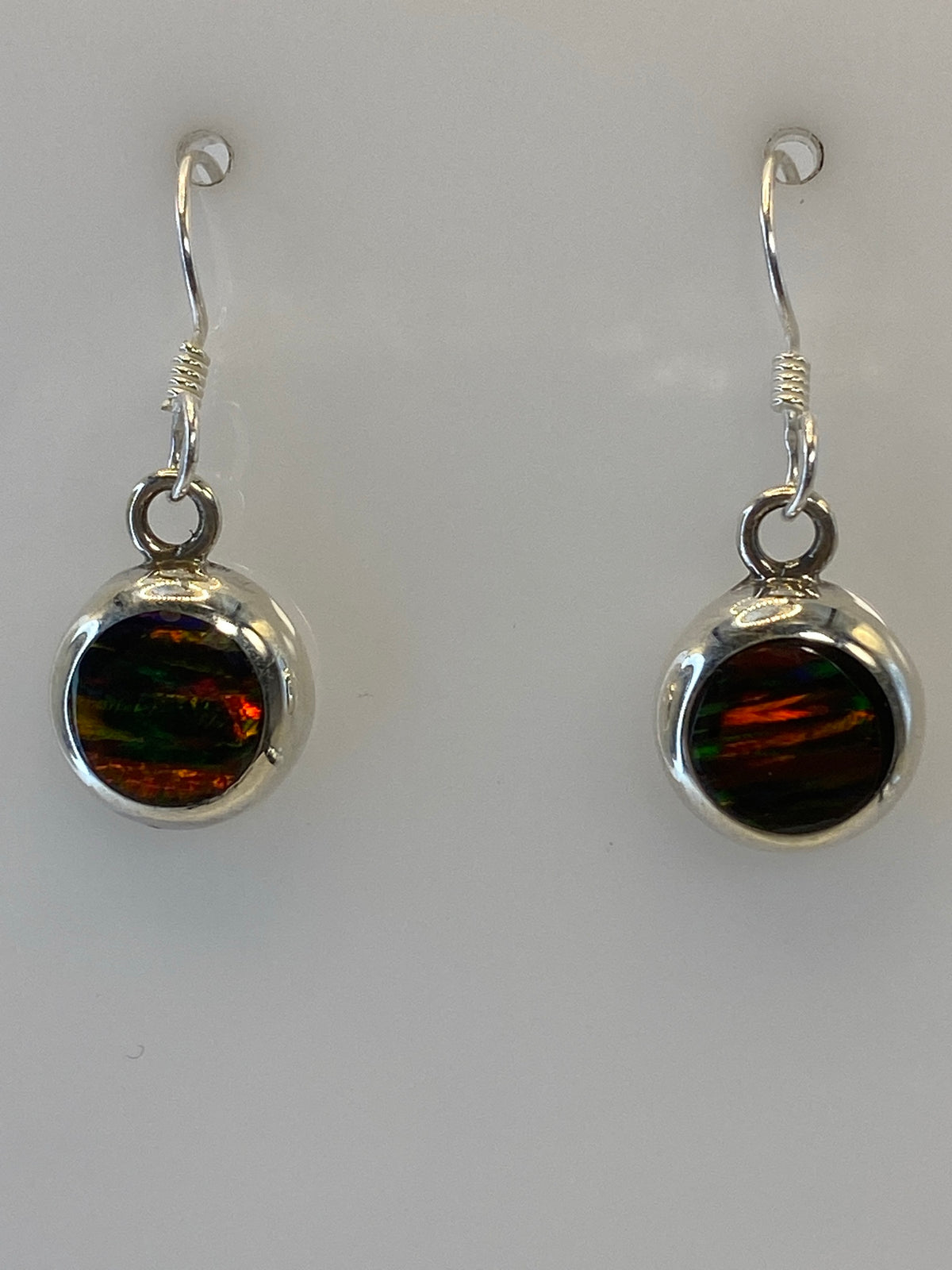 Aretes sobre fondo neutro mostrando el tamaño de 2.3 cm de largo