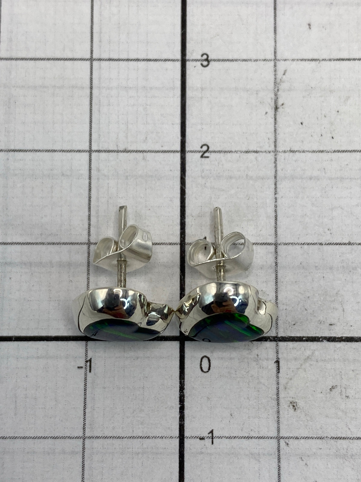 Dorso de los aretes revelando la marca 925 y el engaste de la piedra