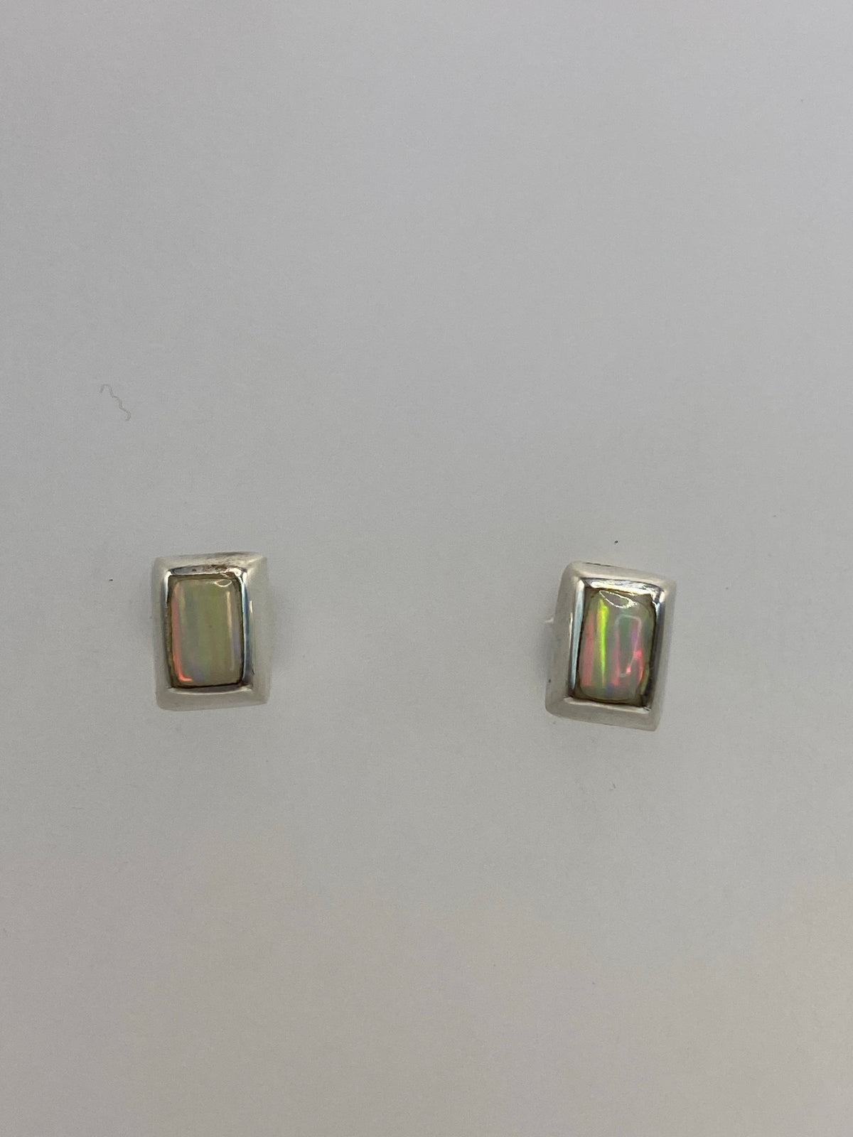 Par de aretes de plata con ópalo de fuego blanco en caja de presentación