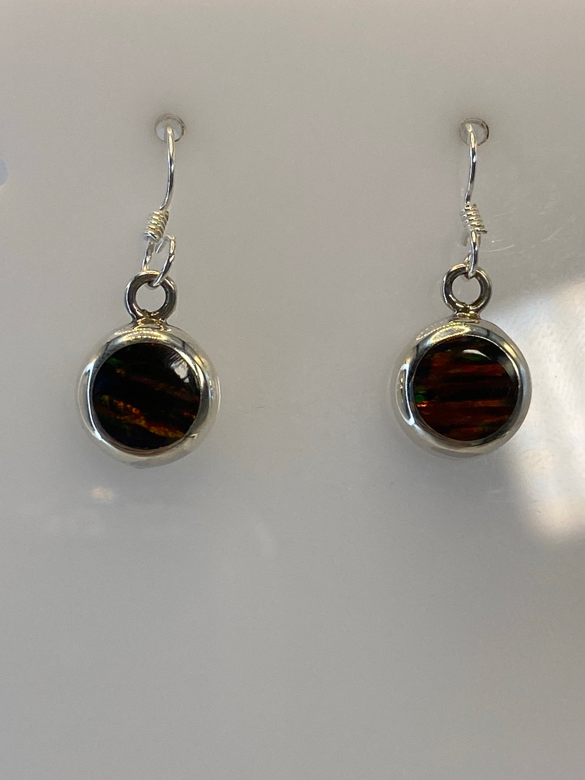 Close-up of fire opal gemstone in silver 950 setting showing orange and red fire reflections