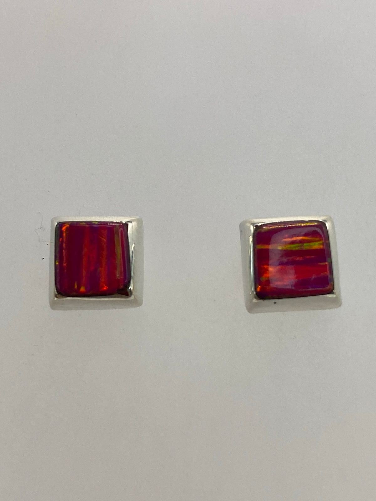 Detalle del ópalo de fuego rosa en los aretes mostrando las vetas naturales
