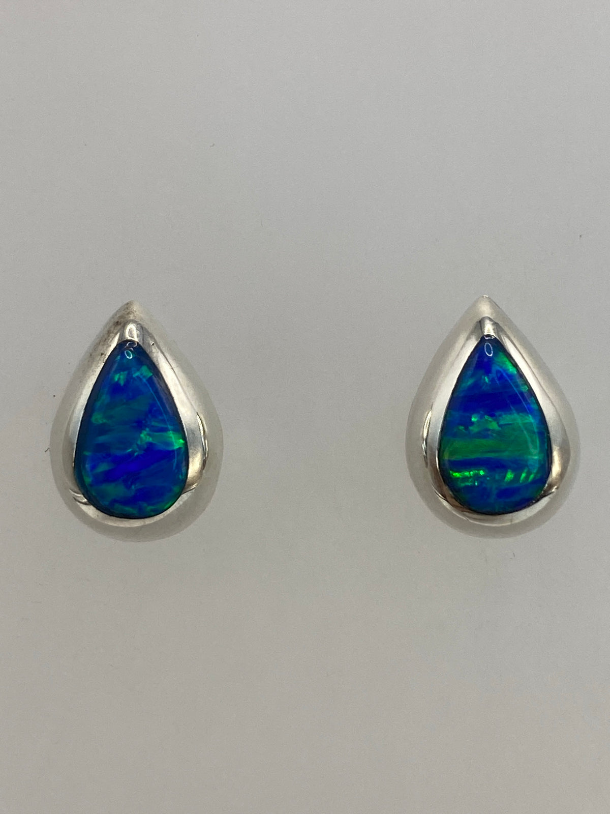 Aretes sobre regla de centímetros mostrando tamaño discreto de 1.3 cm