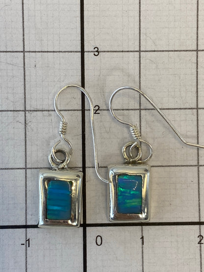 Ópalo de Fuego multicolor en los aretes, reflejando tonos naranja y verde