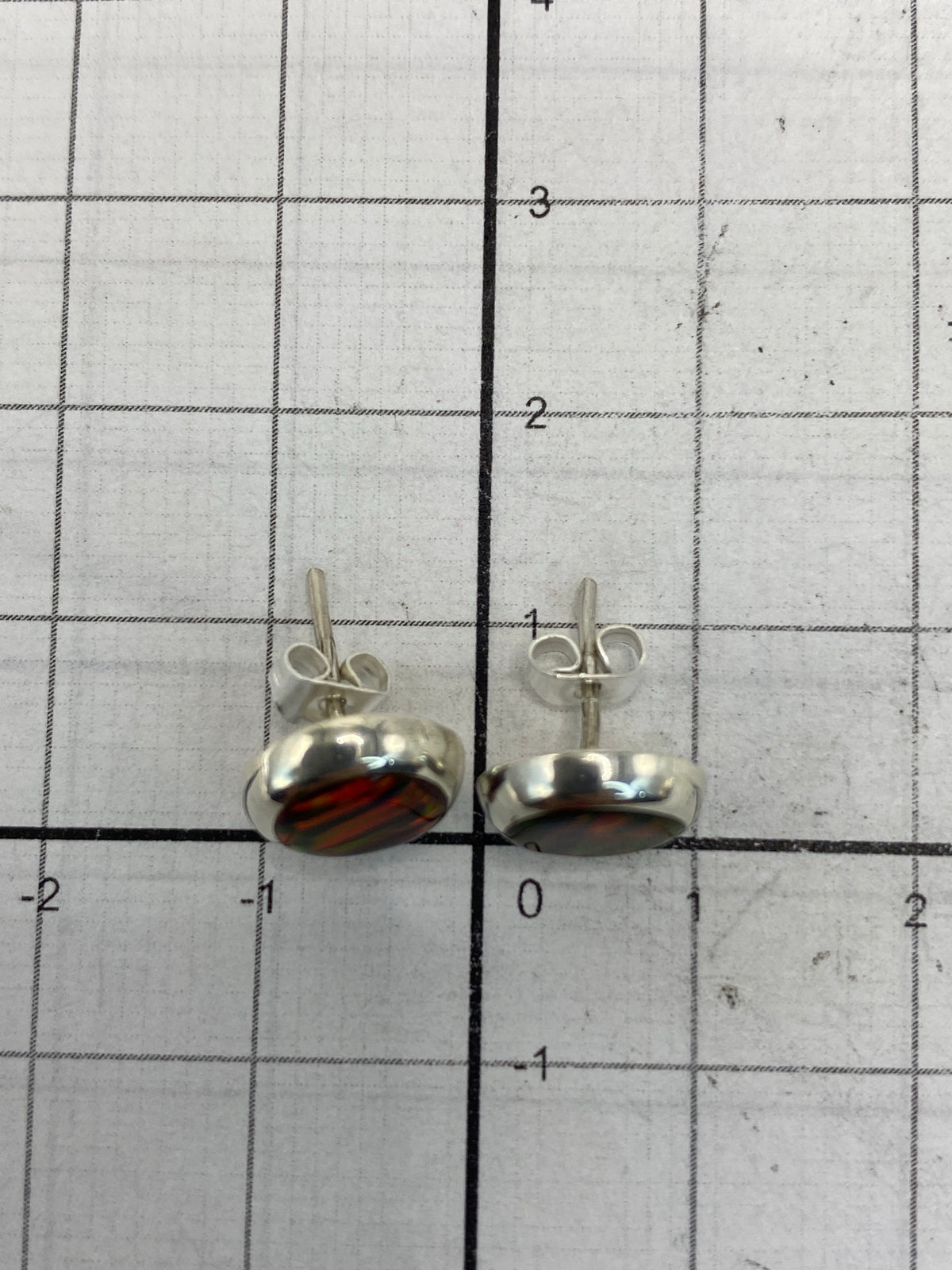 Reverso de los aretes mostrando el Quinto 925 y presilla de plata