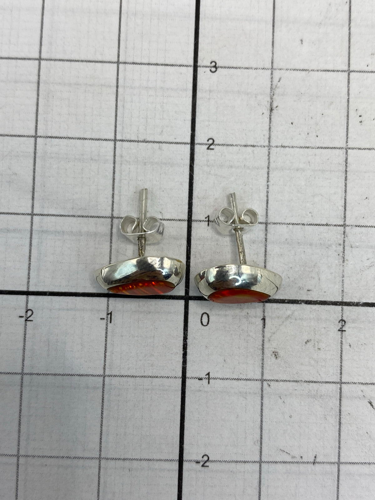 Aretes sobre escala con el Quinto 925 visible en el reverso