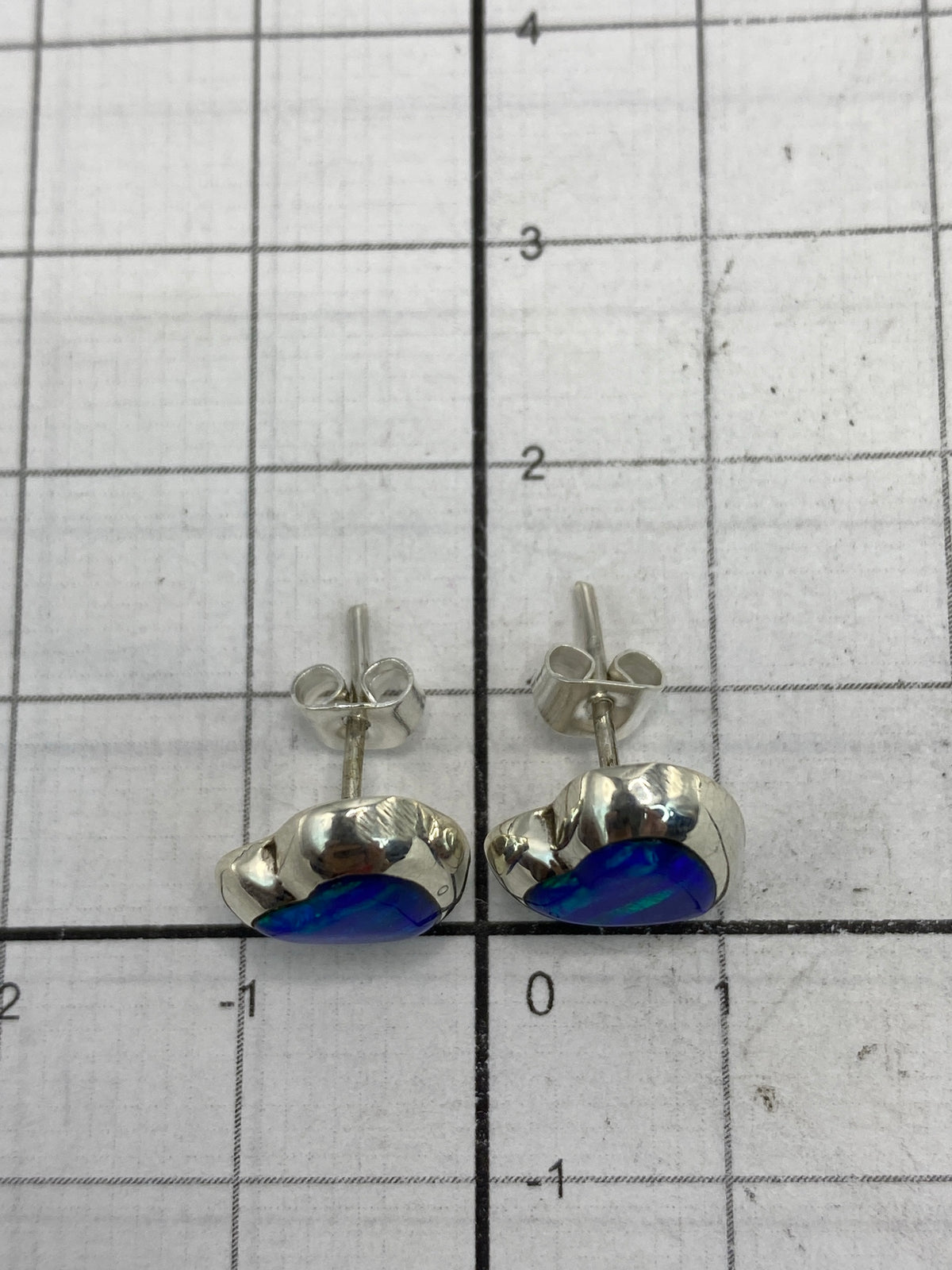 Reverso de los aretes mostrando el Quinto 925 y los pernos de presión