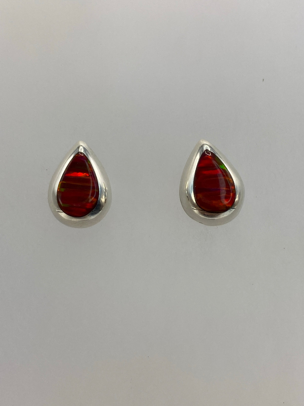 Detalle del arete mostrando el ópalo de fuego rojo en engaste de plata 925