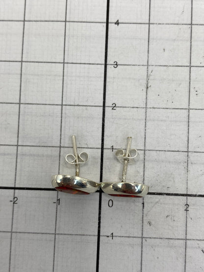 Aretes en la mano mostrando el tamaño discreto y el brillo luminoso del ópalo