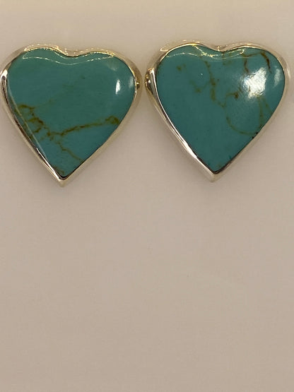 Aretes de plata con turquesa en la mano mostrando el tamaño discreto de 1.8 cm