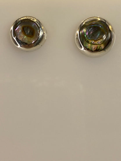 Detalle de los aretes mostrando la incrustación de piedra a mano en plata