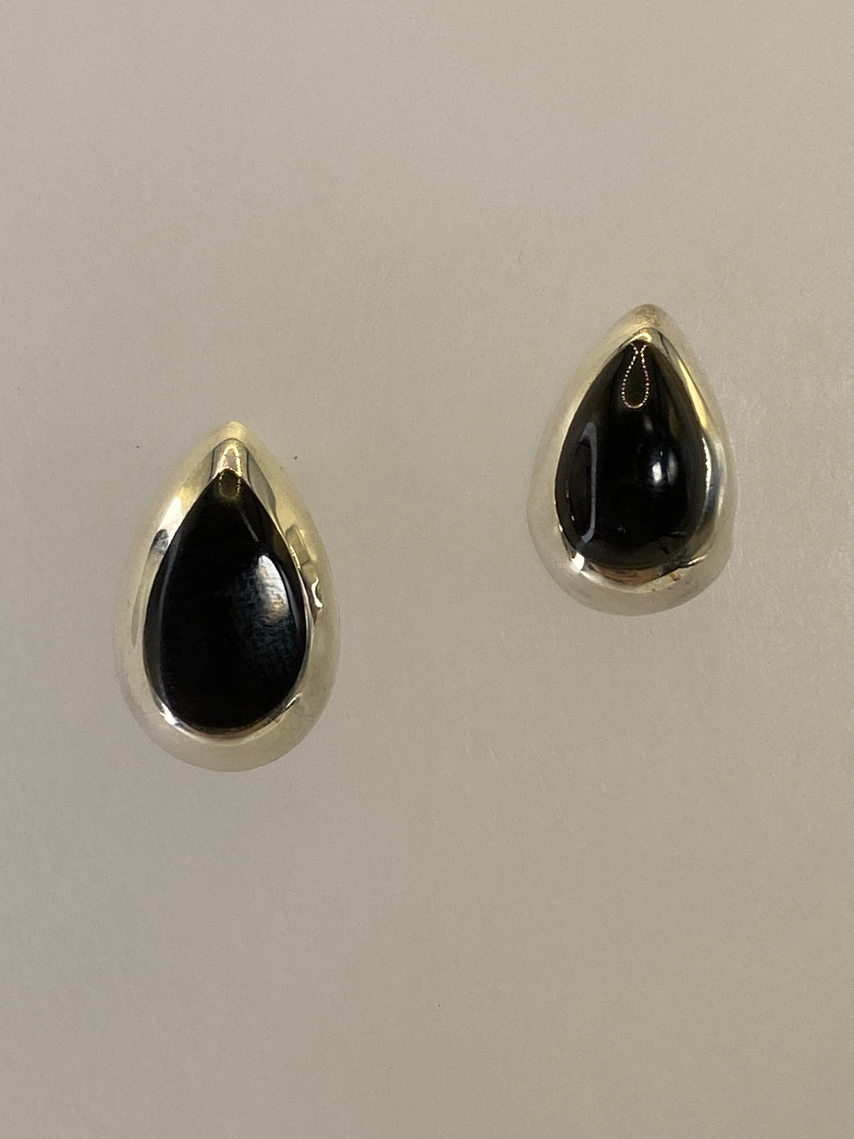 Par de aretes de plata 925 con ónix negro engastado, ante fondo blanco