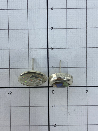 Los aretes sobre regla mostrando el tamaño real de 1.3 cm de largo