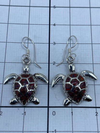 Aretes sobre escala de medición mostrando largo de 3.3 cm