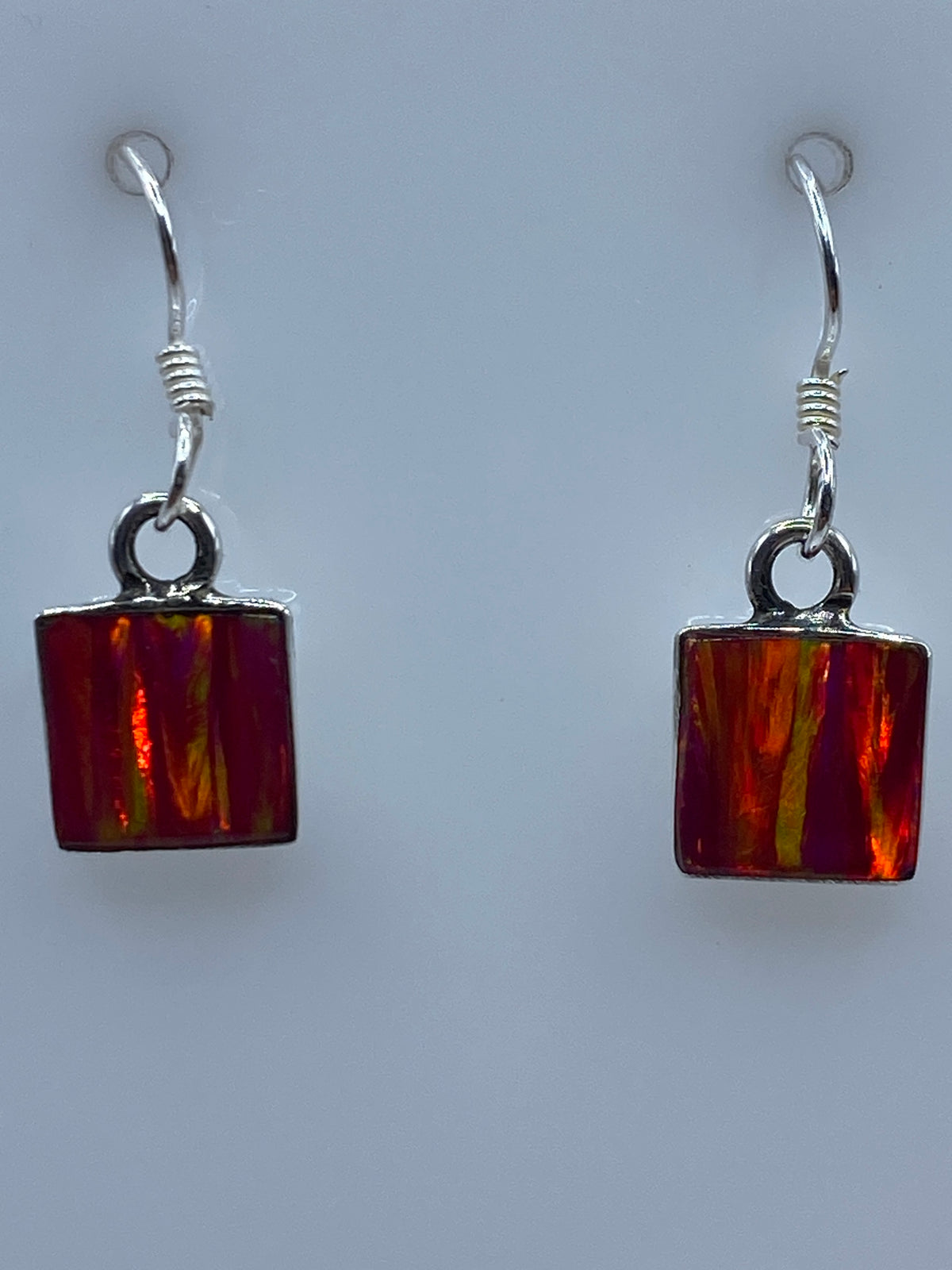 Vista frontal de ambos aretes, destacando la tonalidad rosa y naranja del ópalo