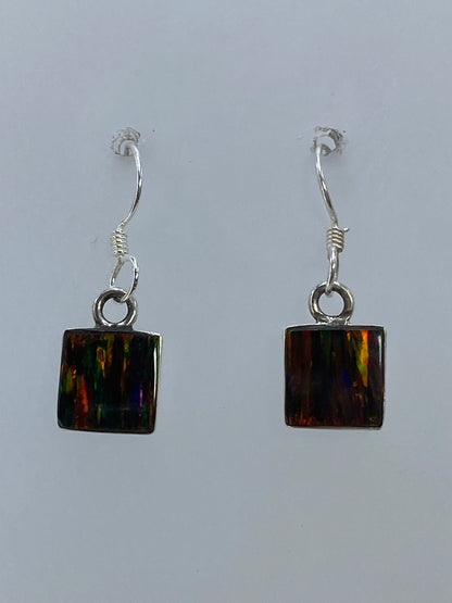 Par de aretes de plata con ópalo de fuego multicolor, junto a escala de medición mostrando 2.3 cm