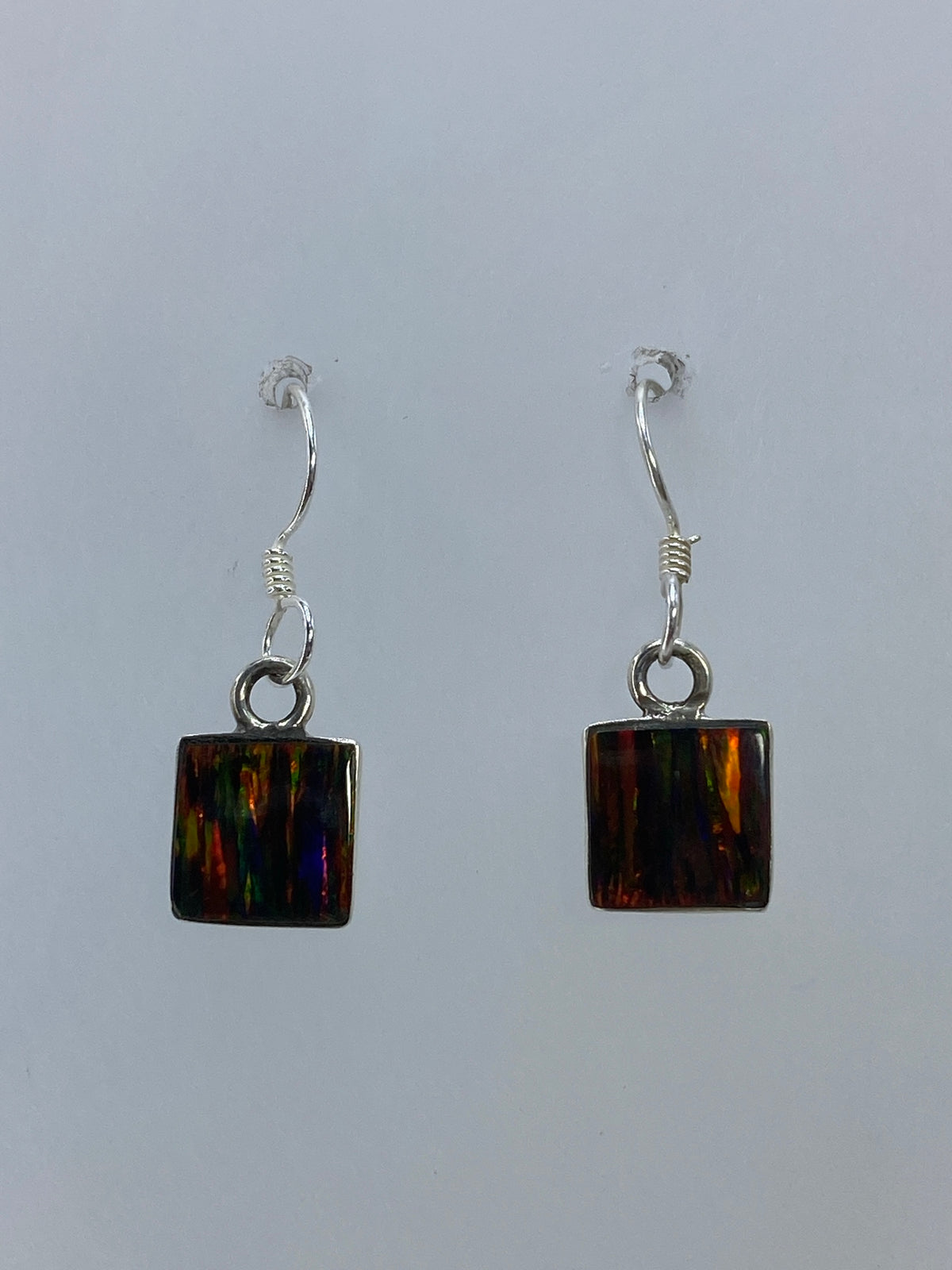 Aretes de plata 925 con ópalo de fuego engastado, detalle del cierre en gancho