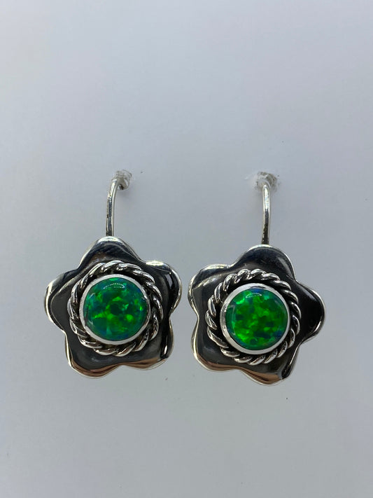 Par de aretes en forma de flor de plata 950 con ópalo de fuego verde limón, vistos de frente