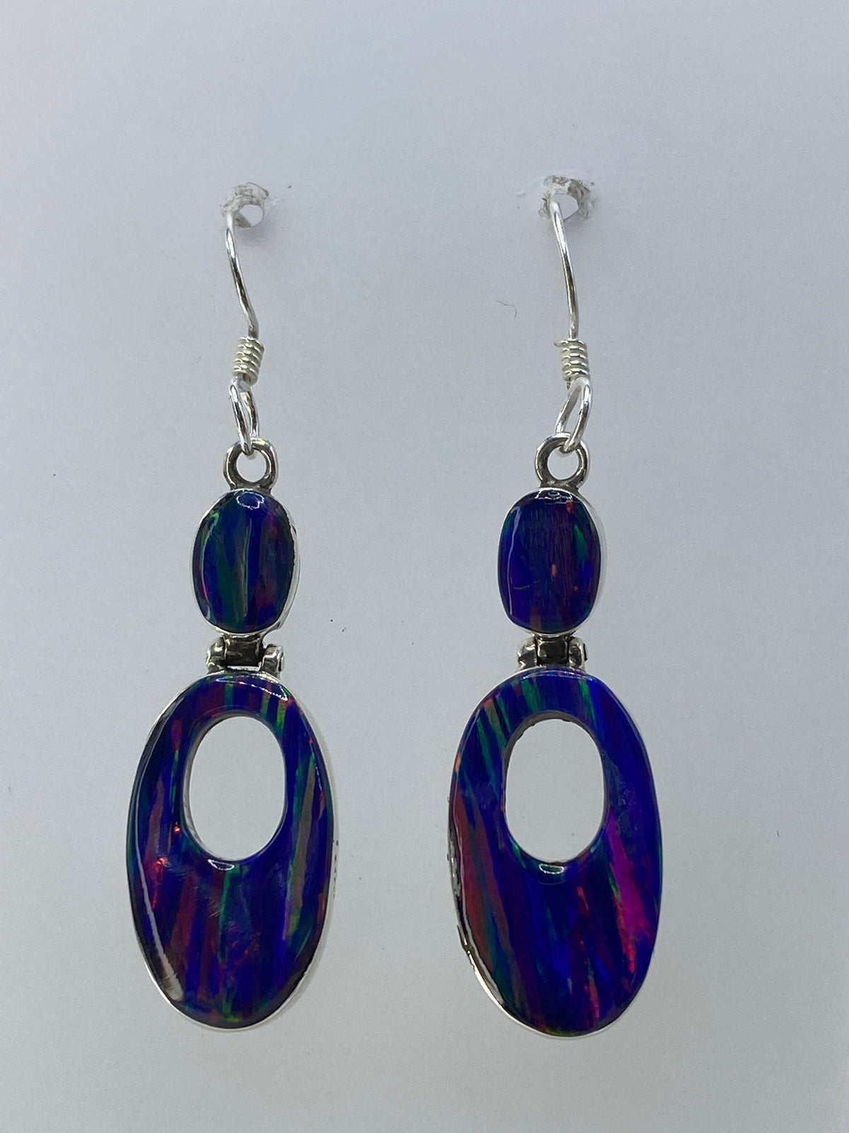 Detalle del ópalo de fuego multicolor con tonos rojo, verde y azul en los aretes